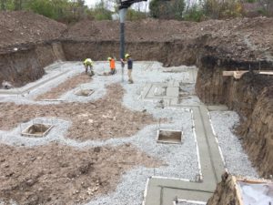 Using conveyor to stone footings for new home foundation